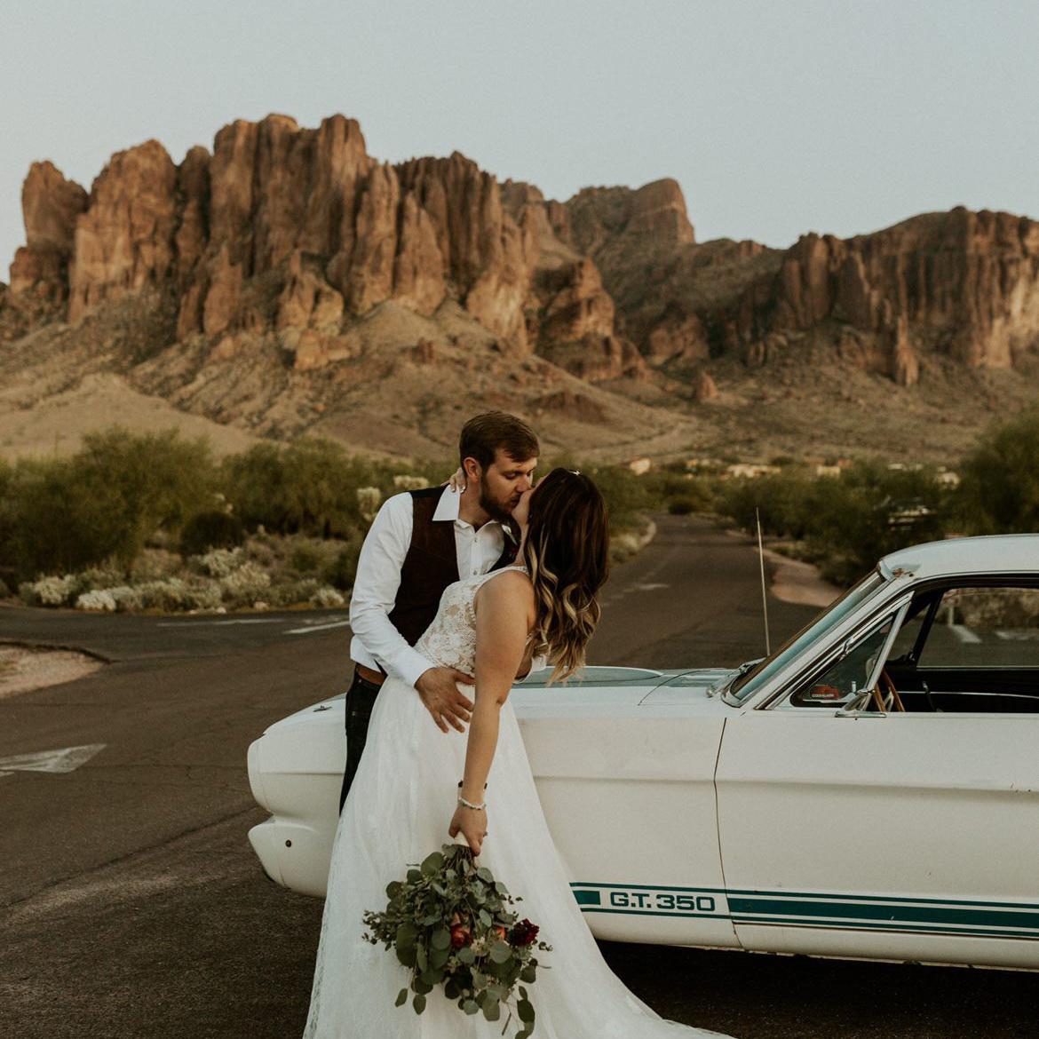 Bride & groom with classic Americana muscle car with majestic views of Superstition Mountains