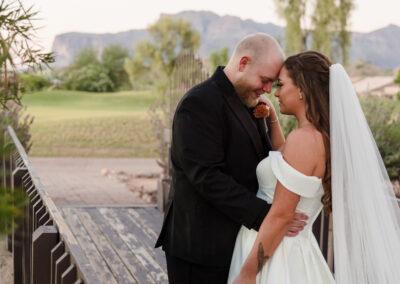 Bride and groom on a bridge with majestic views of the Superstition mountains