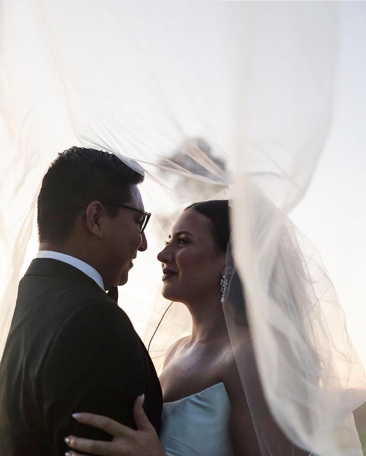 Bride and groom on a bridge with majestic views of the Superstition mountains